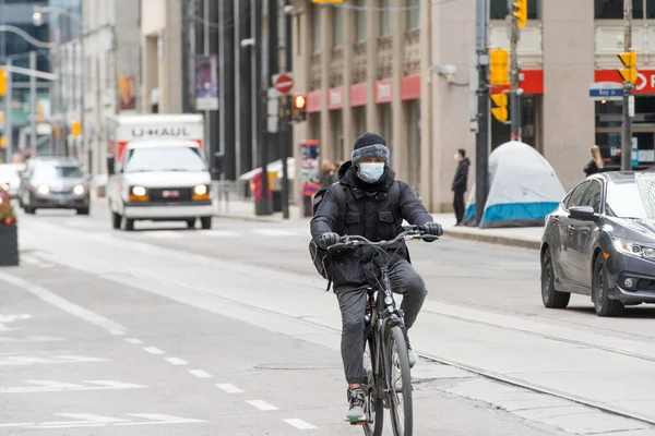 stock image Cyclist rides his bike, wearing face masks due to COVID-19 Pandemic. 