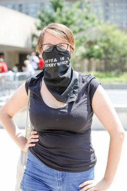 TORONONTO, ONTARIO, Kanada - 11 Ağustos 2018: Yüzünde 'ANTIFA Her Yerde' yazan bandanalı maskeli AntiFA üyesi. 