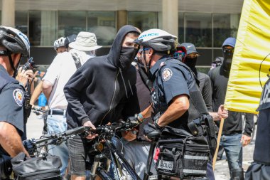 Maskeli AntiFA üyesi polisle karşı karşıya. 