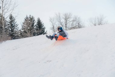 TORONONONTO, ONTARIO, Kanada - 25 ARALIK 2020 ARALIK: ANLAR VE ÇOCUKLARI KIŞ GÜNDE TOBOGANLAR