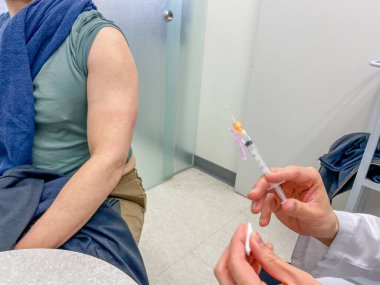 TORONONTO, ONTARIO, CANADA - 20 Nisan 2021: 40 YAŞINDA YAŞINDA MERKEZİ ASTRAZENECA VACCINE COVID-19 PANDEMIK.