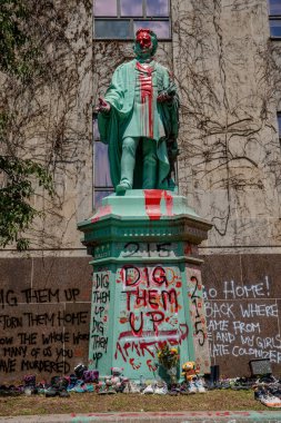 Ryerson Üniversitesi kampüsündeki Egerton Ryerson 'ın heykeli kırmızı boyayla boyanmış, heykelin etrafına 215 ayakkabı serilmiş, geçen hafta Kamloops, BC' deki toplu mezarlarda bulunan 215 cesedin bulunduğuna atıfta bulunulmuştu.