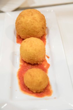 Seramik tabakta servis edilen soslu lezzetli yemekler.