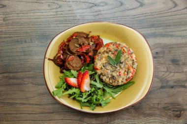 Ahşap masada seramik tabakta sunulan lezzetli yiyecekler: yukarıdan manzara