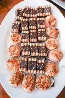 Oval tabak dolusu süslü kek ve kek.