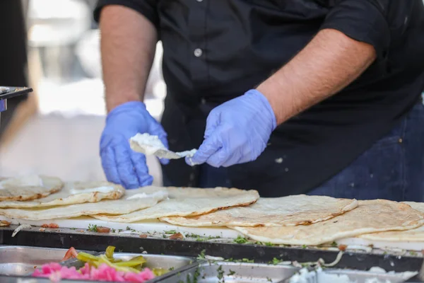 Sokakta shawarma yapan eldivenli erkeklerin yakın çekimi