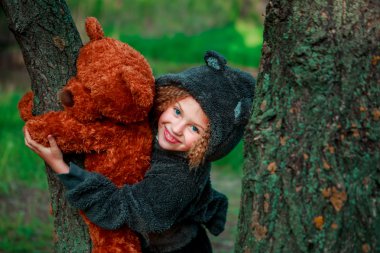 Kız ve ayıcık ağaçta.