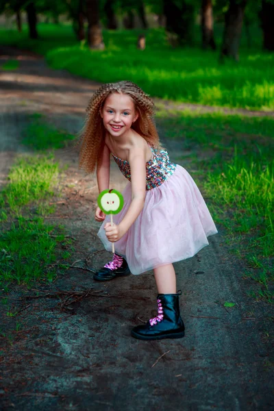 Блондинка, стоящая на тропинке и держащая в руках конфетку . — стоковое фото