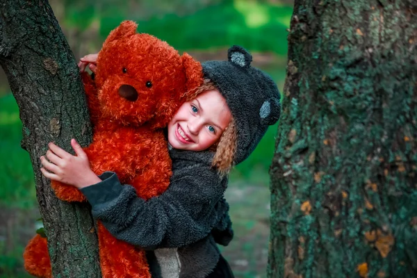 Holčička a medvídek na stromě. — Stock fotografie