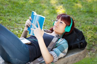 Genç kız bir kitap okur ve müzik