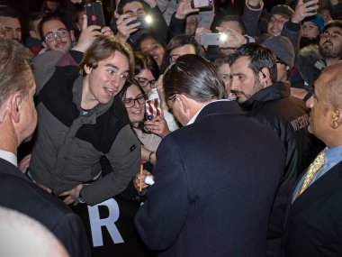 Roma, İtalya - 15 Ocak 2016: Leonardo DiCaprio 'nun sokakta halka imza dağıtması. Aktörün etrafı İtalyan hayranlar ve güvenlik görevlileriyle çevrili. Halka açık bir yerdeyiz, onu alacak olan kırmızı marangoza girmeden önce. 