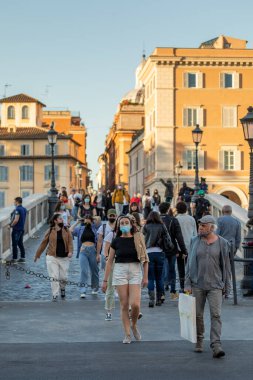 Roma, İtalya - 26 Mayıs 2021: Bir grup insan, vatandaş ve turist, tarihi şehir merkezinde bulunan Trastevere yakınlarındaki Ponte Sisto boyunca yürüyorlar..