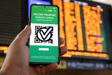 Covid-19 salgını sırasında güvenli bir şekilde seyahat etmek için dijital aşı pasaportlu akıllı telefon uygulaması. Tren istasyonu ya da havaalanı.