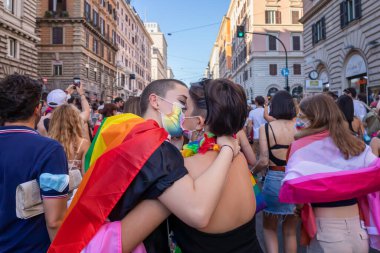 Roma, İtalya - 26 Haziran 2021: LGBT topluluğunun hakları için düzenlenen evrensel gösteri, şehrin sokaklarında gösteri yapan iki genç kadın öpüşüp sarılıyor..
