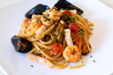 Deniz mahsullü linguine. Domates sosu, karides, mürekkep balığı ve deniz ürünlerinden oluşan tipik İtalyan mutfağı yemeği (linguine)..