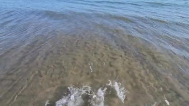 透明かつ透明な海の水の表面は 海はビーチで小さな波を生成します — ストック動画