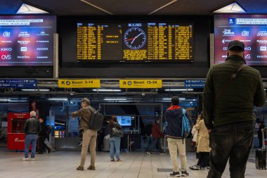 Napoli, İtalya - 6 Kasım 2025: Merkez İstasyonu 'nun içinde, platforma ulaşmak için gelen ve giden yolcularla birlikte tren geliş ve gidişlerini gösteren büyük pano.