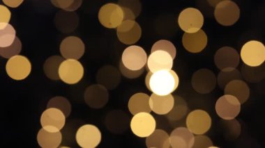 Yanıp sönen sarı Noel ışıkları ve bulanıklıktan gelen bokeh. Koyu arkaplan.