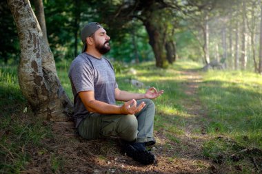 Ormanda meditasyon yapan bir adam. 