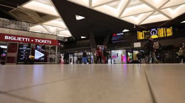 Napoli, İtalya - 19 Şubat 2026: Napoli Merkez İstasyonu 'nun modern geometrik tavanı gösteren geniş bir iç çekim. Bir grup yolcu, bilet gişelerinin ve kalkış panolarının yakınındaki ana salondan hızla geçiyor..