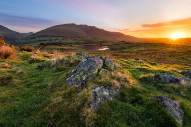 Güneşin baş döndürücü doğuşuyla göldeki kayaları aydınlatan güzel bir sabah ışığı.