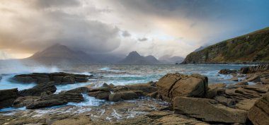 İngiltere 'nin Skye Adası' ndaki Elgol 'da karamsar dramatik gökyüzü dalgaları kıyıya vuruyor..