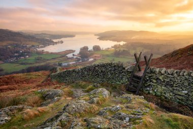 Windermere üzerinde güzel bir gün batımı. Göl Bölgesi 'nde. Önünde ince ve taş bir duvar var..