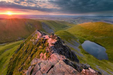 Blencathra Dağı sırtında küçük bir göl ve gölle baş döndürücü bir gün doğumu..