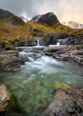 Deepdale Beck Akıntısı 'nda dramatik bulutlar ve dağ sıraları. Lake District, İngiltere.