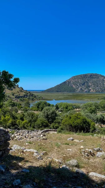 Bir göl manzarası ve bir tepeden dağlar..