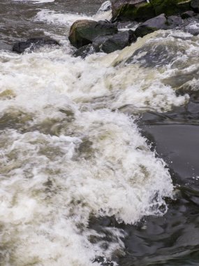 A large body of water with rocks in the background.
