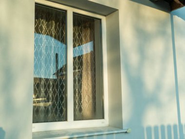 Beyaz çerçeveli ve pencere pervazlı bir pencere.