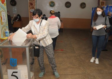 Bir sonraki yerel seçimlerde, Kiev 'deki oy kullanma merkezlerinden birinde, 25 Ekim 2020' de bir seçmen sandığa oy attı..