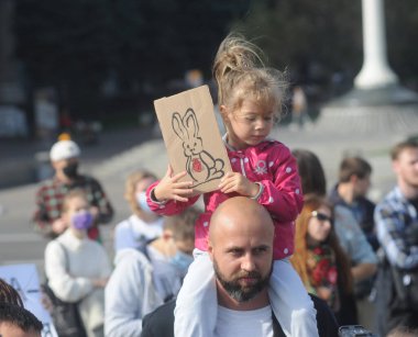 4 Ekim 2020 'de Kiev' de düzenlenen Dünya Hayvan Günü mitinginde bir çocuk elinde tavşanla bir poster tutuyor.