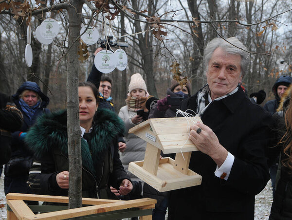 Former President of Ukraine Viktor Yushchenko hangs up a bird feeder during the All-Ukrainian action "Feed the Birds in Winter" in Goloseevsky Park in Kiev, December 8, 2020.