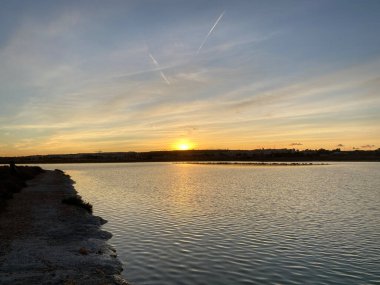 İspanya 'da günbatımı kırsal çiftlik ve tuz gölü ufuk çizgisi manzarası