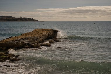 Deniz dalgaları İspanya 'nın Alicante kentinde bulunan plajda kayaya çarpıyor.,
