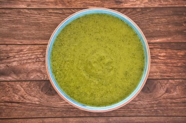 Kahverengi ahşap masadaki bezelyelerden yapılmış taze sebze detoks çorbası. Üstü açık, yazı için yeri var. Lezzetli