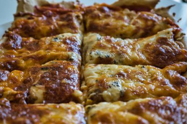 Lezzetli ev yapımı sıcak İtalyan pizzası yemeye hazır. Domates, jambon, mozzarella peyniri ve dört peynirli. Tat