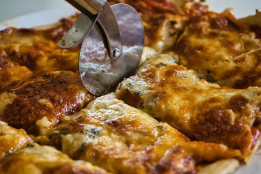 Lezzetli ev yapımı sıcak İtalyan pizzası yemeye hazır. Domates, jambon, mozzarella peyniri ve dört peynirli. Tat