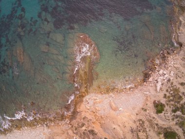 Denizin drone görüntüsü, Calpe sahilinde dalgalar ve kayalar, Alicante, İspanya 'da yer alıyor. manzara
