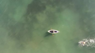 view from a drone of a kayak and a trained swimmer in the sea on a beach in Alicante, Spain