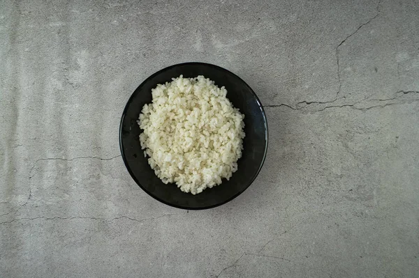 Fekete Tányér Főtt Rizzsel Asztalon Élelmiszer — Stock Fotó