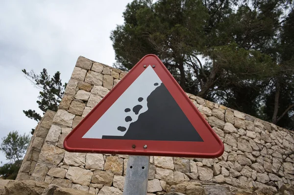 cave-in danger sign with stones and trees behind. view