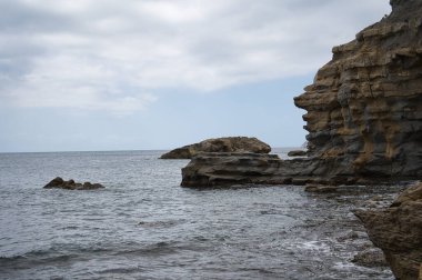 İspanya 'nın Valensiyalı topluluğu Alicante eyaletinde Morarira kasabasının kıyısında kayalıkları olan bir plaj. görünüm
