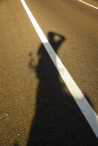Shadow of a person on the street in the evening sun