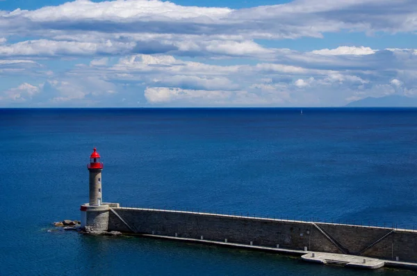 Faro frente al mar azul, tranquilo y cielo nublado. Copiar espacio para caracteres o letras — Foto de Stock