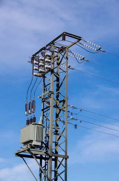 Electricity mast with transformers in front of blue blue sky
