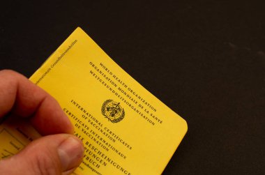 Bamberg, Almanya - 14-05.2021. Siyah bir arkaplana karşı aşı kartıyla.