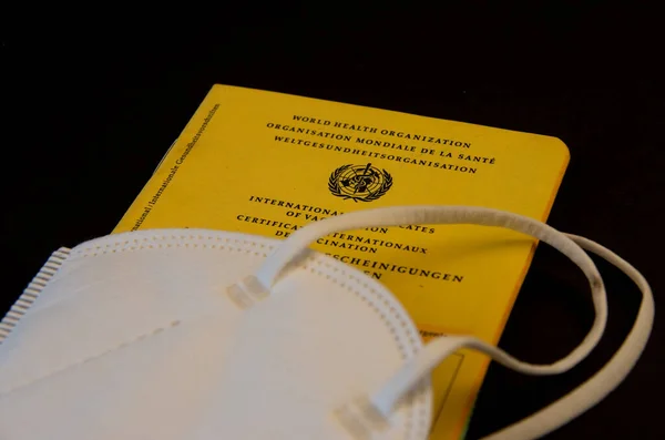 Bamberg, Germany - 14-05.2021. Vaccination pass and ffp2 mask against a black background — Stock Photo, Image